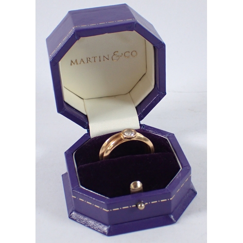 410 - An 18 carat gold matching wedding ring and engagement ring by Martin & Co, the collet set diamond ap... 