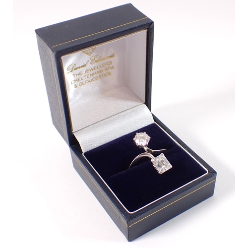 411 - A Toi et Moi platinum and diamond two stone crossover style ring, the round brilliant cut 1ct diamon... 