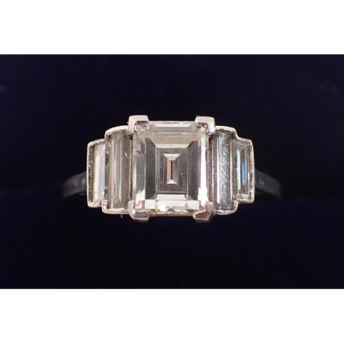 412 - An Art Deco platinum and diamond ring with emerald cut diamond 1.52cts, flanked either side by two g... 