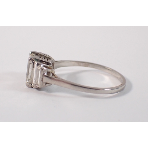 412 - An Art Deco platinum and diamond ring with emerald cut diamond 1.52cts, flanked either side by two g... 