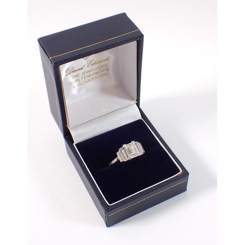 412 - An Art Deco platinum and diamond ring with emerald cut diamond 1.52cts, flanked either side by two g... 