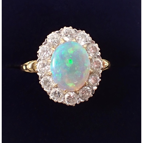 413 - An 18ct gold oval cut opal ring with diamond surround, size P, opal 10 x 8mm, diamonds 3mm, 4.2g, ma... 