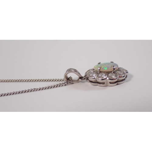414 - An 18ct white gold oval cut opal pendant with diamond surround on 9ct gold chain, opal 9 x 7mm, diam... 