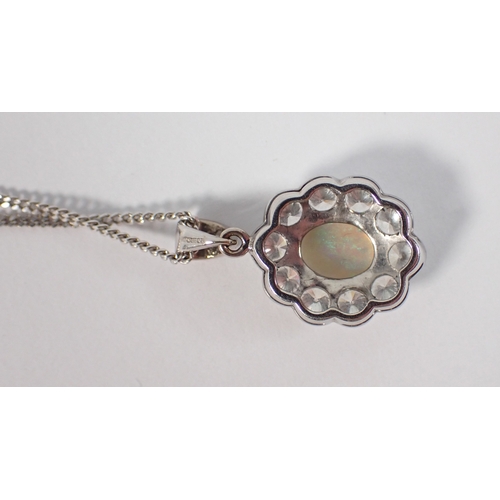 414 - An 18ct white gold oval cut opal pendant with diamond surround on 9ct gold chain, opal 9 x 7mm, diam... 