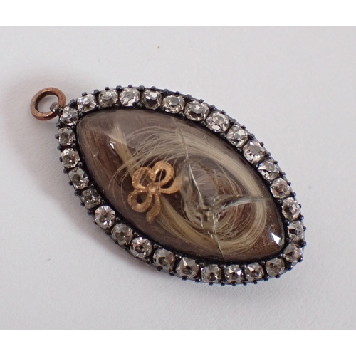 421 - A yellow metal mourning brooch / pendant within 28 diamond surround 3cm long