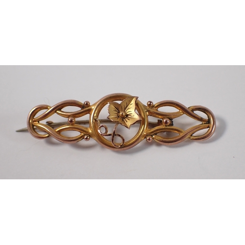 422 - A Victorian 9ct gold brooch with central ivy leaf in ball and scrollwork surround, 4.5cm wide, 1.7g