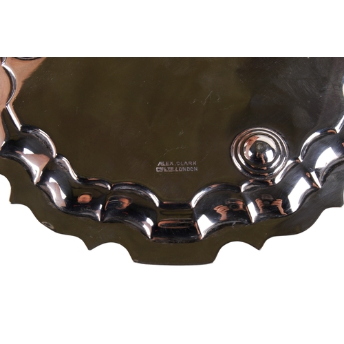 18 - A George V silver salver. Having a shaped and embossed border, a monogram engraved to the centre, on... 