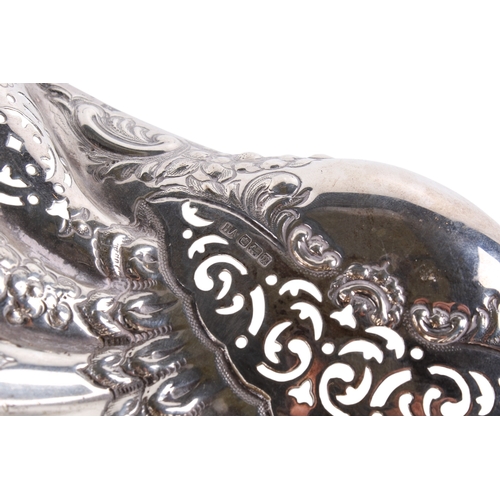 4 - A George V silver bowl. Of shell shape and pierced and embossed foliate decoration, on three conch s... 