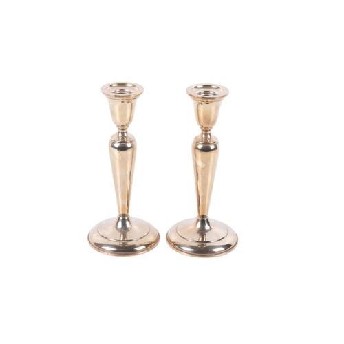 19 - A pair of Cartier silver candlesticks. Weighted, of classical form on a spread foot. Marked 'Cartier... 