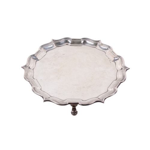 2 - An Edwardian silver salver. Having a shaped moulded rim, on three pad feet, hallmarked Hawksworth, E... 