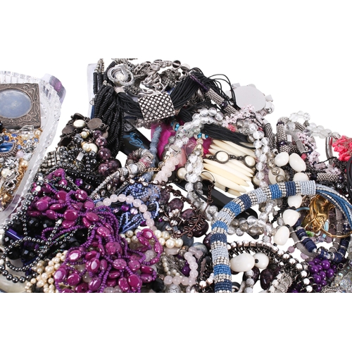 228 - A collection of costume jewellery. Including many beaded necklaces, brooches, a small silver photogr... 