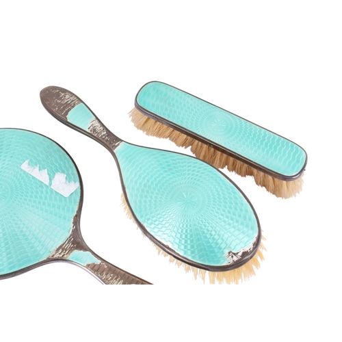 30 - A silver and turquoise enamel dressing table set. Comprising hand mirror, two brushes, three glass p... 