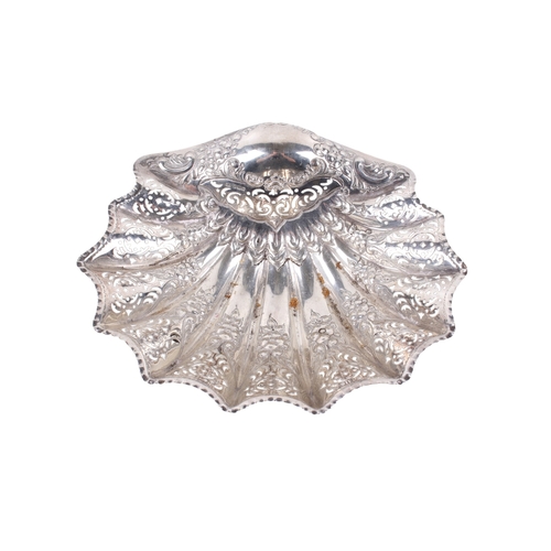 4 - A George V silver bowl. Of shell shape and pierced and embossed foliate decoration, on three conch s... 