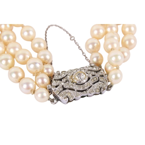 241 - A vintage faux pearl three-string bracelet. With an ornate silver and paste clasp, marked sterlg, th... 