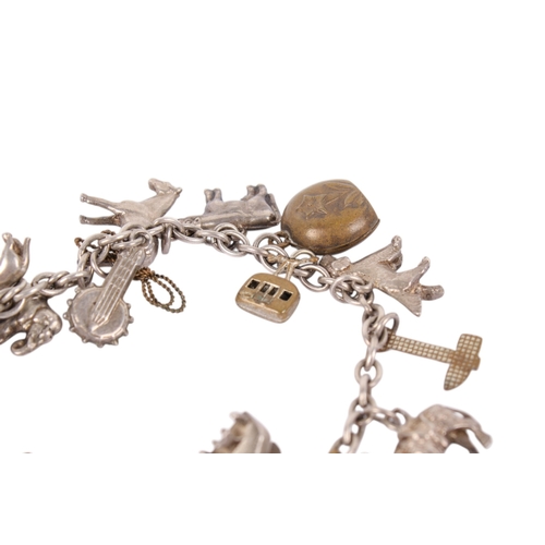 245 - A white metal charm bracelet. Charms including animals, a yacht, cow bell, etc, gross weight 33g.