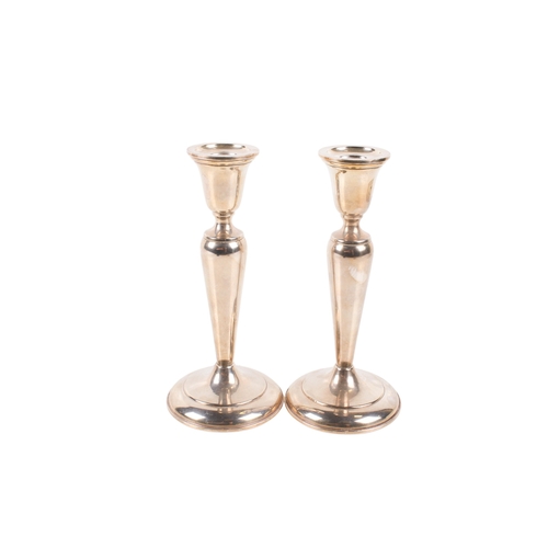 19 - A pair of Cartier silver candlesticks. Weighted, of classical form on a spread foot. Marked 'Cartier... 