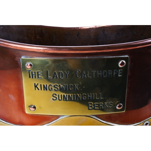 231 - A 19th century brass and copper coal bucket. Of oval form, with a swing handle and a brass plaque ma... 