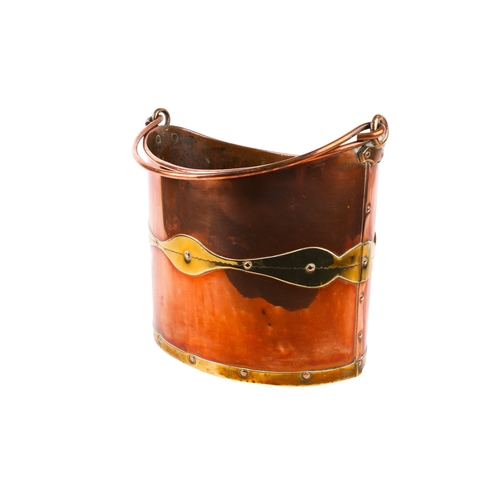 231 - A 19th century brass and copper coal bucket. Of oval form, with a swing handle and a brass plaque ma... 