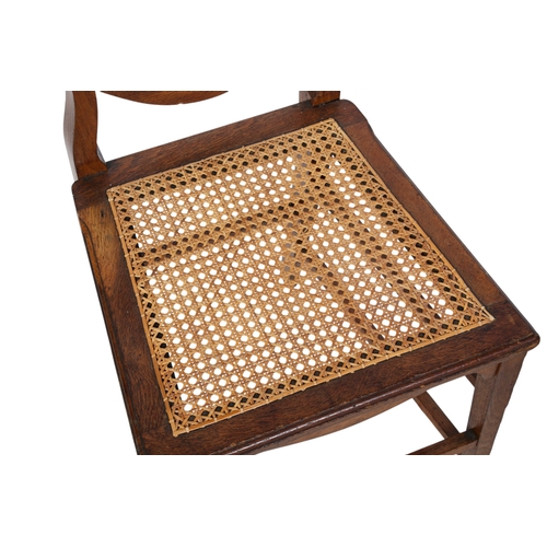 420 - A pair of Scottish hall chairs. The wooden framed chairs with shield backs, shaped slats and rattan ... 