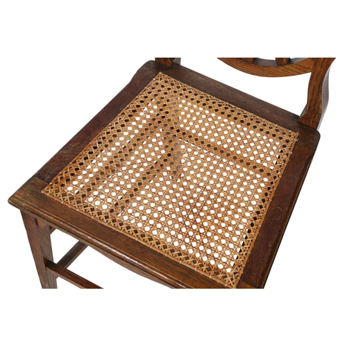 420 - A pair of Scottish hall chairs. The wooden framed chairs with shield backs, shaped slats and rattan ... 