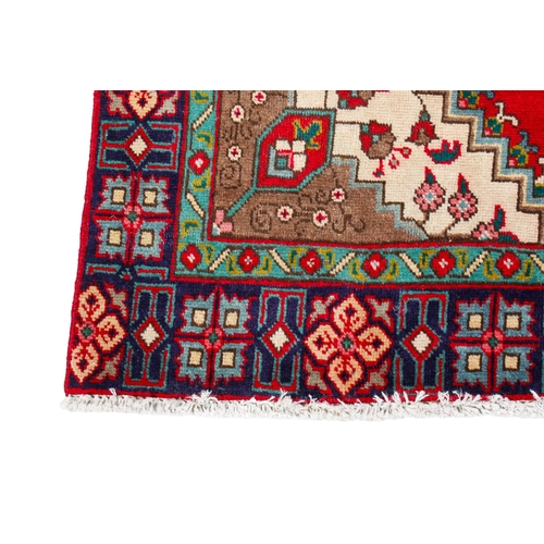 456 - A vintage Persian rug. The central panel featuring a blue medallion surrounded by flowers and on a r... 