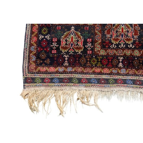453 - A rust red and green patterned prayer rug. The shaped central motif on a dark blue ground with multi... 