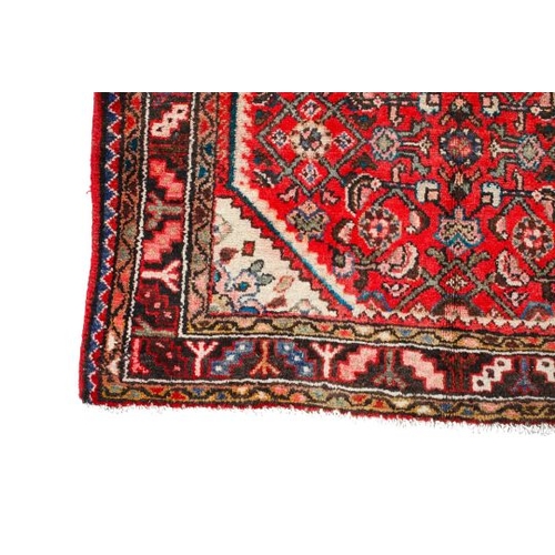 463 - A vintage Persian rug. The central octagonal panel heavily decorated with flowers and geometric patt... 