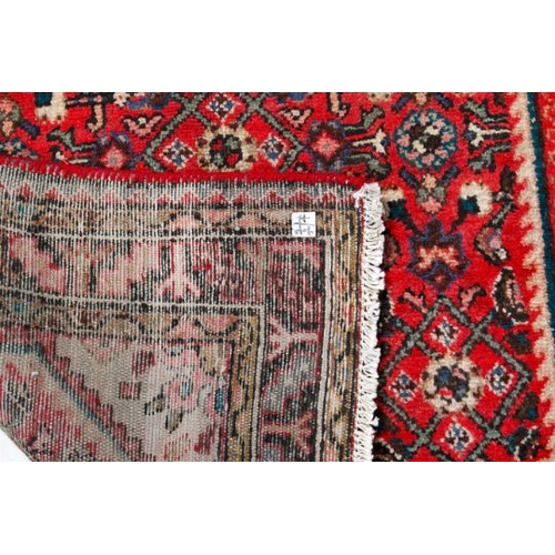 463 - A vintage Persian rug. The central octagonal panel heavily decorated with flowers and geometric patt... 