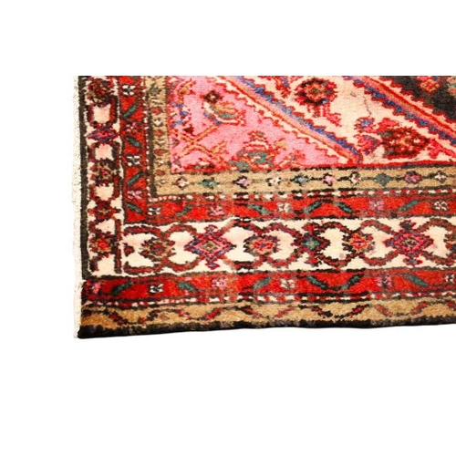 466 - A Persian style woollen rug. The diamond shaped medallion on a red ground, surrounded by cream borde... 