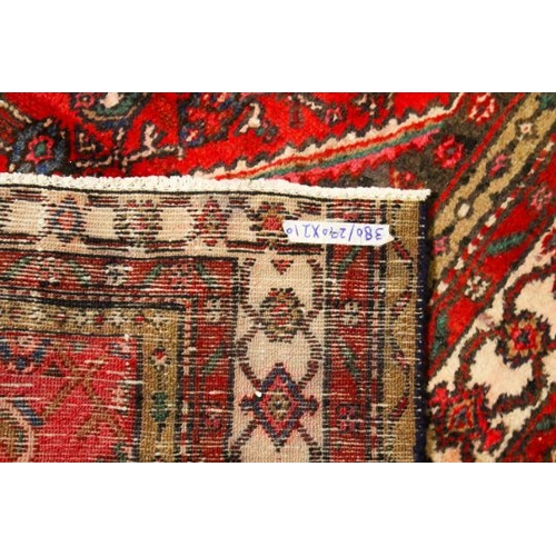 466 - A Persian style woollen rug. The diamond shaped medallion on a red ground, surrounded by cream borde... 