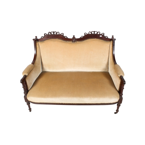 441 - A Regency style two seater sofa. Having carved ribbon and leaf decoration, raised on tapering fluted... 