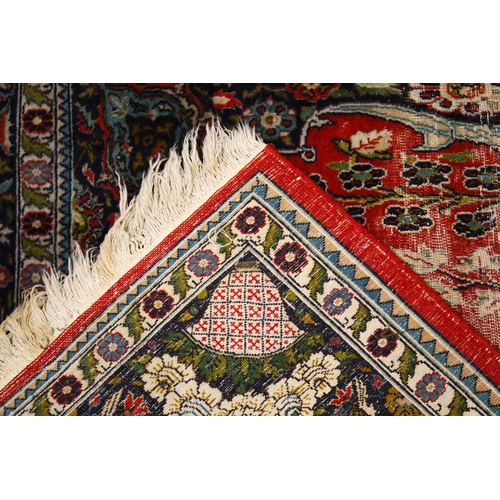 473 - A small Kashmiri rug. With vases and floral sprays on a red and pale blue ground, surrounded by a da... 