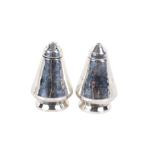 62 - A 20th century silver 'space rocket' salt and pepper set. Of tapered form with circular weighted bas... 