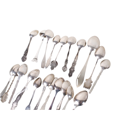 69 - A collection of white metal teaspoons. The handles decorated with embossed flowers, architecture and... 