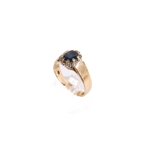 164 - A 9ct gold and sapphire dress ring. The oval faceted stone circa 5mm x 4mm surrounded by tiny diamon... 