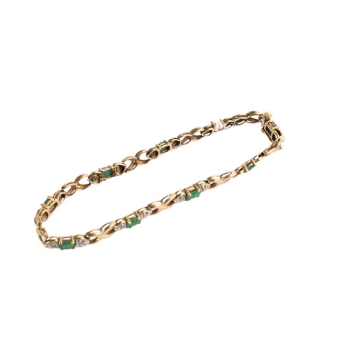 170 - A gold and emerald fancy bracelet. Each oval cut emerald flanked by two small diamonds and crossver ... 
