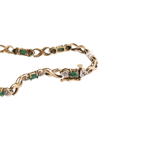 170 - A gold and emerald fancy bracelet. Each oval cut emerald flanked by two small diamonds and crossver ... 