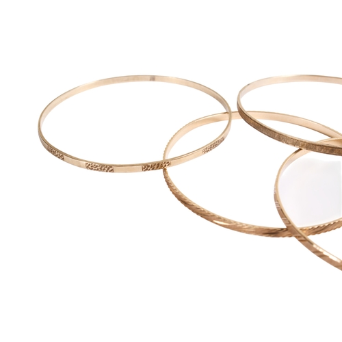 198 - Seven 9ct gold (tested) narrow flat bangles of various designs, some marked. Gross weight 49.8g.