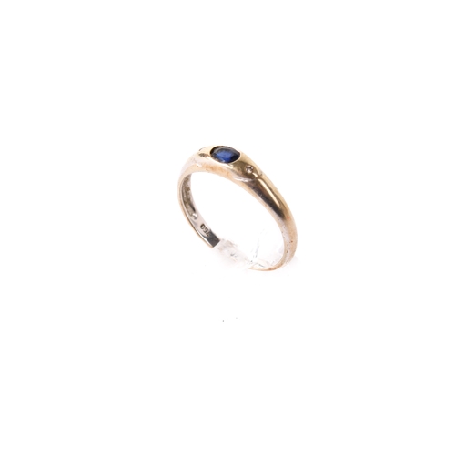 277 - A yellow metal, sapphire and diamond three stone ring. The oval cut blue sapphire flanked by round c... 
