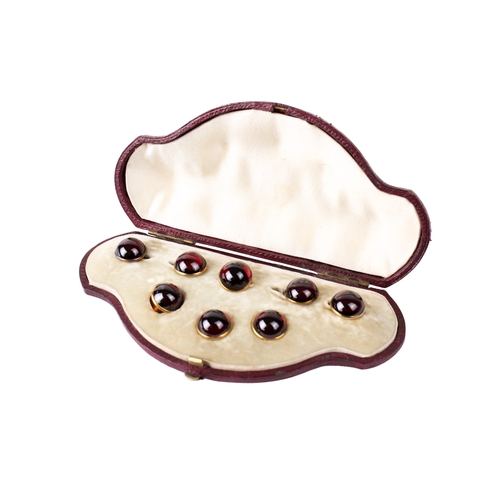 319 - A set of eight yellow metal and red paste dress studs and links. Each diameter 1.2cm, metal unmarked... 