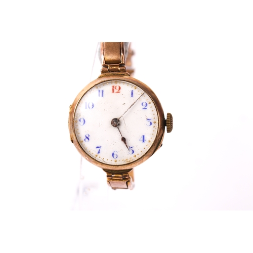 395 - A 9ct gold ladies wristwatch. The white enamel dial with blue and red Arabic numerals, in a 9ct gold... 