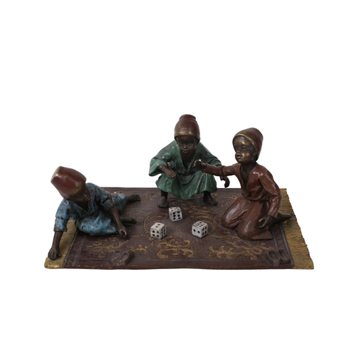 506 - A Bergman Austrian cold painted bronze figural group. Modelled as three figures rolling dice, seated... 