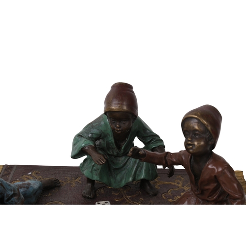 506 - A Bergman Austrian cold painted bronze figural group. Modelled as three figures rolling dice, seated... 