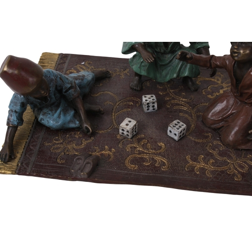 506 - A Bergman Austrian cold painted bronze figural group. Modelled as three figures rolling dice, seated... 