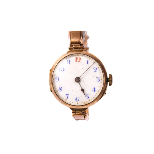 395 - A 9ct gold ladies wristwatch. The white enamel dial with blue and red Arabic numerals, in a 9ct gold... 