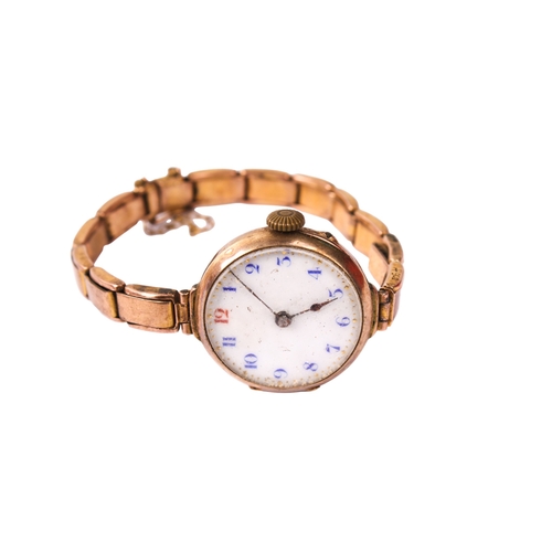 395 - A 9ct gold ladies wristwatch. The white enamel dial with blue and red Arabic numerals, in a 9ct gold... 