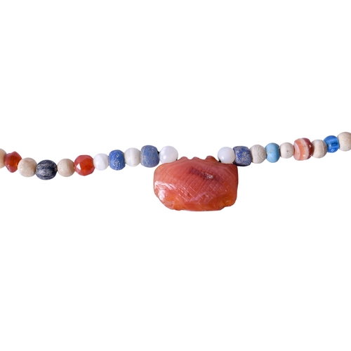 62 - A string of possibly Roman beads with an amygdaloid carnelian pendant, possibly Minoan. The small be... 