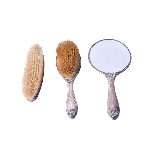 144 - An early 20th century silver backed dressing table set. Comprising two brushes and a mirror, all hav... 