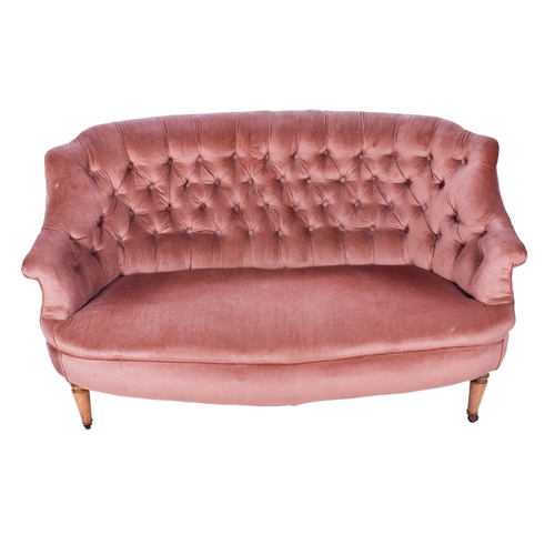 158 - A 20th century curved wingback sofa. Upholstered in pink fabric with a button back, raised on wooden... 