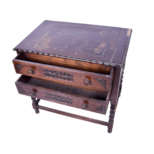 166 - A carved oak writing table. Having two graduated drawers with turned handles, raised on barley twist... 